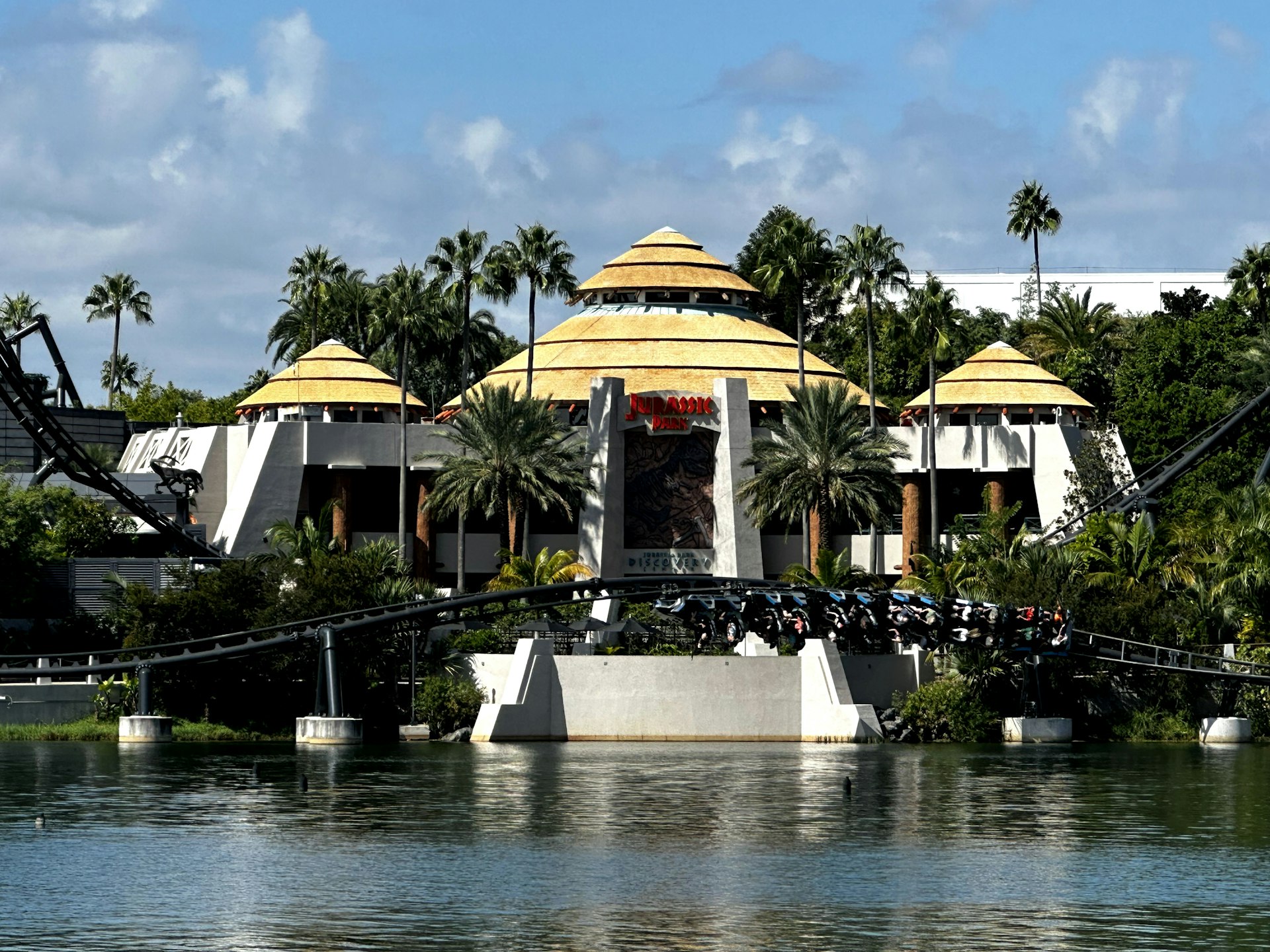 a large building with a yellow roof next to a body of water